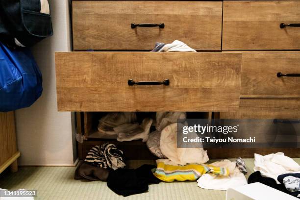 clothes scattered in disorder and a wardrobe left open - chest of drawers stock pictures, royalty-free photos & images