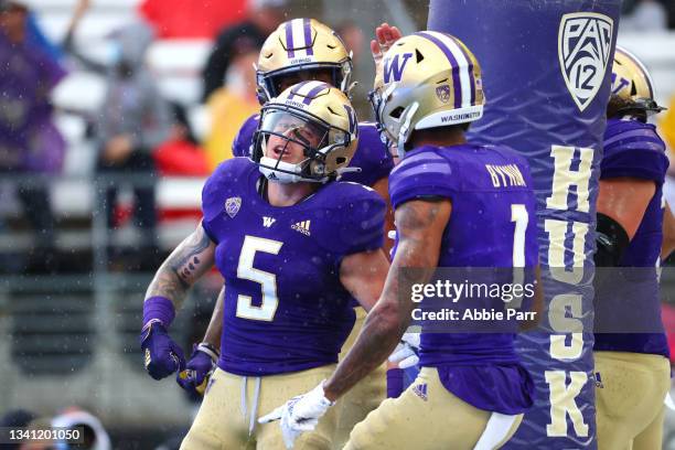 Sean McGrew of the Washington Huskies celebrates his touchdown with teammates against the Arkansas State Red Wolves during the first quarter at Husky...