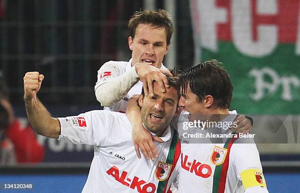 Sebastian Langkamp, Edmond Kapllani and Paul Verhaegh of Augsburg celebrate Kapllani's first goal during the Bundesliga match between FC Augsburg and...