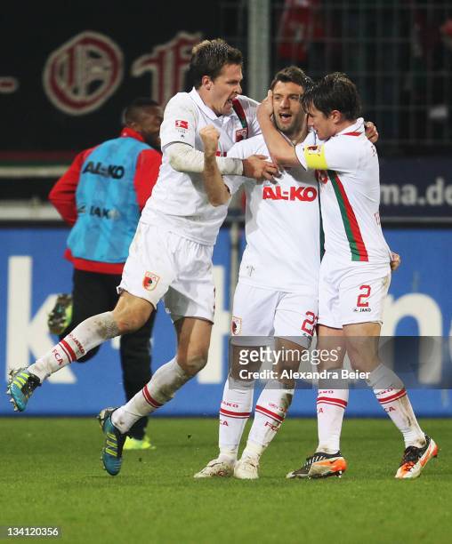 Sebastian Langkamp, Edmond Kapllani and Paul Verhaegh of Augsburg celebrate Kapllani's first goal during the Bundesliga match between FC Augsburg and...