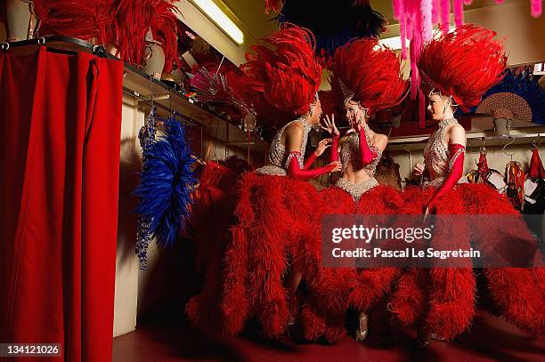 Twenty-year-old dancer Morgan Kenny poses with dancers Katie Hayward and Jessie Toone backstage at the Moulin Rouge on September 13, 2011 in Paris,...