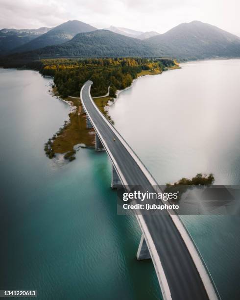 woman crossing the bridge over lake on a foggy winter day. - river aerial view stock pictures, royalty-free photos & images