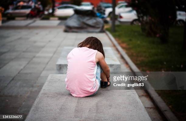 little girl sitting alone on the bench - sweet little models stock pictures, royalty-free photos & images