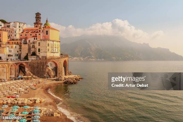 the beautiful amalfi town with shoreline during golden hour during summer in italy. - italy stock-fotos und bilder