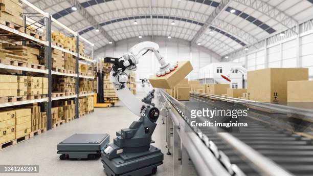 automated robot carriers and robotic arm in smart distribution warehouse - factory stockfoto's en -beelden