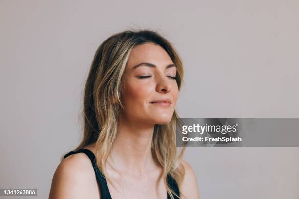 horizontal close up shot of a beautiful blonde woman meditating with her eyes closed - blonde yoga stock pictures, royalty-free photos & images