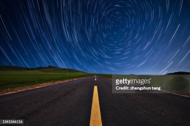 star trails on the highway in wu lan bu tong. - star field stock-fotos und bilder