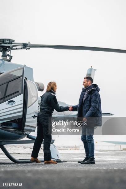 chopper pilot greeting man with handshake - helicopter pilot stock pictures, royalty-free photos & images