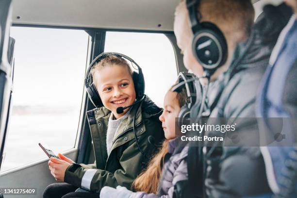 smiling young boy with family on a helicopter ride - helikopter stockfoto's en -beelden