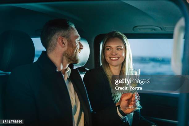 young wealthy couple drinking wine while travelling in a car - happy anniversary stock pictures, royalty-free photos & images