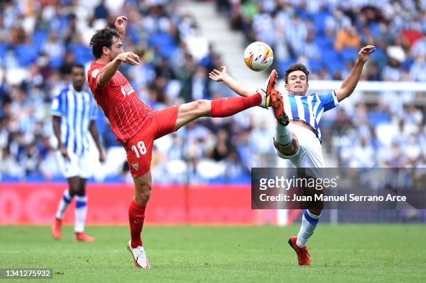 Martin Zubimendi of Real Sociedad and Thomas Delaney of Sevilla battle for possession during the La Liga Santander match between Real Sociedad and...