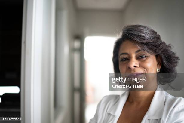 portrait of a confident female doctor - mature adult with doctor stock pictures, royalty-free photos & images