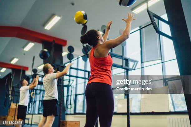 aula de exercícios agachada com bolas esportivas - treinamento em circuito - fotografias e filmes do acervo