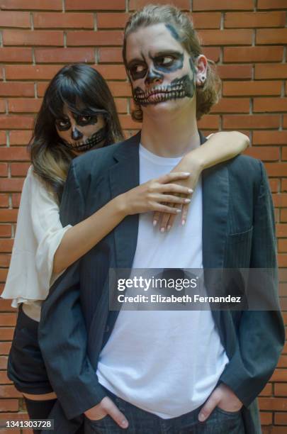 young woman with skull makeup embracing young man with skull makeup from the back, halloween party - megafest 2013 day 2 stock-fotos und bilder