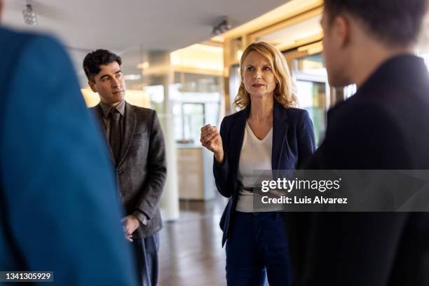 senior businesswoman discussing new ideas in staff meeting - sección del medio fotografías e imágenes de stock