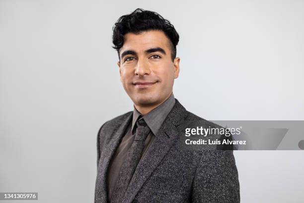 portrait of a confident businessman looking at camera - mid adult men stock pictures, royalty-free photos & images