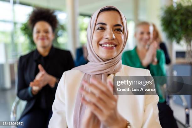 islamic businesswoman clapping hands in a seminar - hoofddoek stockfoto's en -beelden