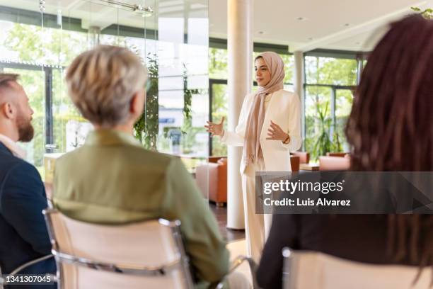 muslim businesswoman giving a speech in a seminar - compere stock pictures, royalty-free photos & images