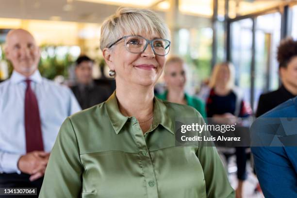 senior woman attending a business conference - senior colored hair stock pictures, royalty-free photos & images