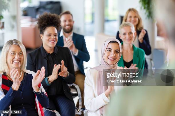 multiracial businesspeople clapping in a management training workshop - awards ceremony stock pictures, royalty-free photos & images