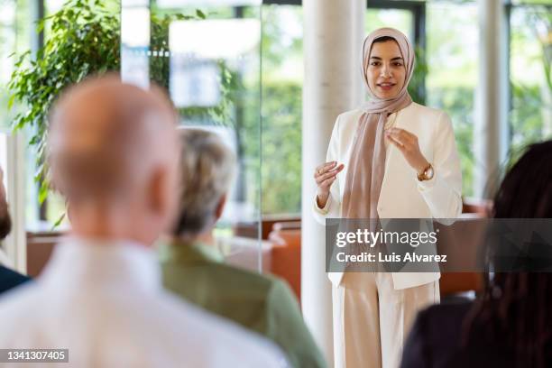 muslim businesswoman addressing the audience in a conference - germany womens team presentation stockfoto's en -beelden