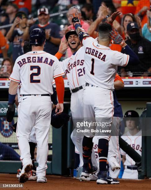 Carlos Correa of the Houston Astros celebrates with Alex Bregman and Jose Siri after hitting a three run home run in the first inning against the...