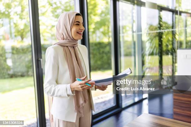 muslima woman professional giving presentation in office boardroom - islam women stock pictures, royalty-free photos & images