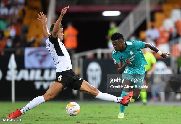 Vinicius Junior of Real Madrid is challenged by Gabriel Paulista of Valencia during the La Liga Santander match between Valencia CF and Real Madrid...