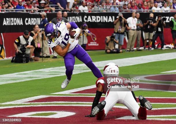 Adam Thielen of the Minnesota Vikings catches a touchdown pass in the end zone as Marco Wilson of the Arizona Cardinals looks on in the first quarter...