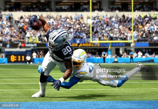 Running back Tony Pollard of the Dallas Cowboys scores a touchdown over defensive back Nasir Adderley of the Los Angeles Chargers during the first...