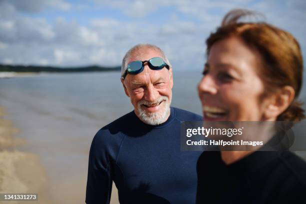 happy active senior couple swimmers after early morning swim in sea, smiling. - old people diving stock pictures, royalty-free photos & images