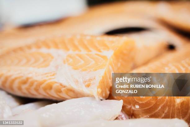 sliced salmon and cod steak on fish display at a fish market. - trout stock photos et images de collection