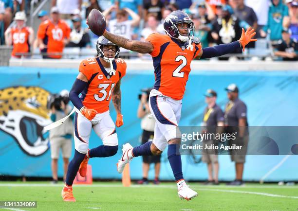 Cornerback Pat Surtain II of the Denver Broncos celebrates an interception with free safety Justin Simmons during the fourth quarter against the...