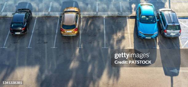 aerial view of four parked passenger cars. - overhead business shadows stock pictures, royalty-free photos & images
