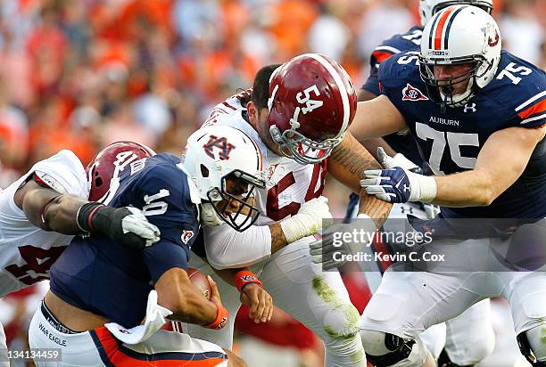 Kiehl Frazier of the Auburn Tigers is sacked by Courtney Upshaw and Jesse Williams of the Alabama Crimson Tide at Jordan-Hare Stadium on November 26,...