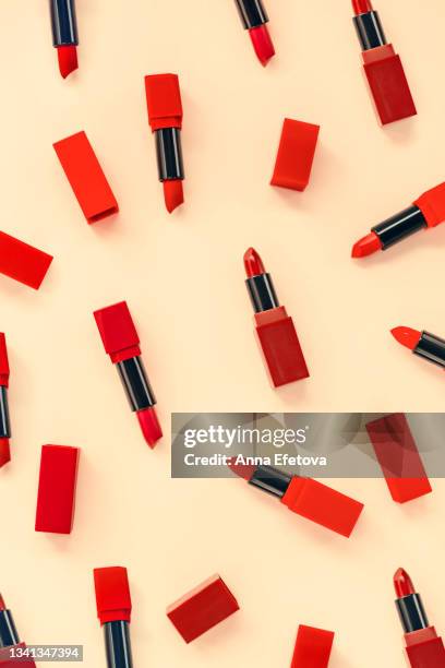 set of various bright red lipsticks on pastel yellow background. flat lay style - 赤の口紅 ストックフォトと画像