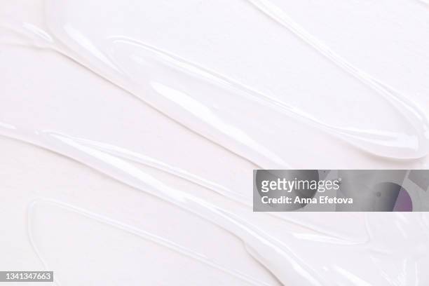 textured smears of transparent gel on white background. flat lay style - gel foto e immagini stock