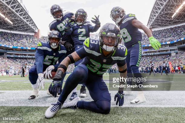 Jamal Adams of the Seattle Seahawks and his teammates celebrate their turnover against the Tennessee Titans during the second quarter at Lumen Field...