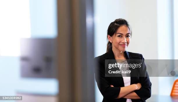 empresaria asiática mirando a cámara con los brazos cruzados - filipino woman fotografías e imágenes de stock