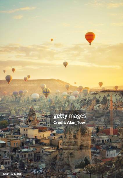 montgolfières survolant la ville d’ürgüp cappadoce, turquie - cheminée de fée photos et images de collection