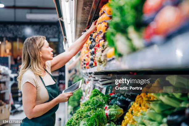 besitzerin, die das inventar im geschäft überprüft - supermarket shelves stock-fotos und bilder