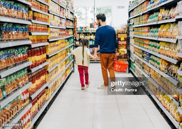 daughter shopping with father in supermarket - cesto de compras imagens e fotografias de stock