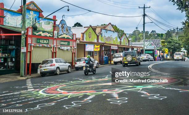 street art in the centre of nimbin village against the backdrop of colourful painted shopfronts, northern rivers area of new south wales - nimbin stock pictures, royalty-free photos & images