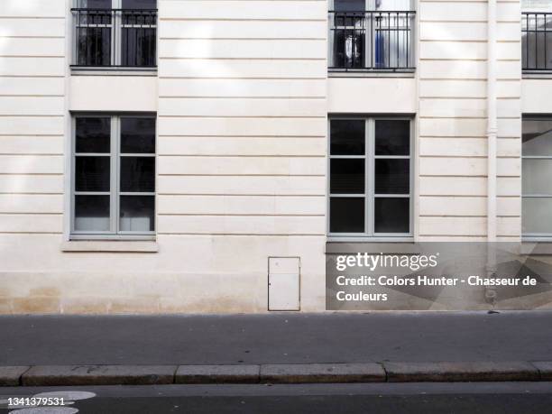 empty and clean building facade in paris with sidewalk and street - european outdoor urban walls stockfoto's en -beelden