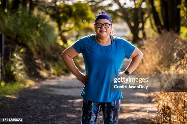 body positive woman running in park - hand on hip stock pictures, royalty-free photos & images