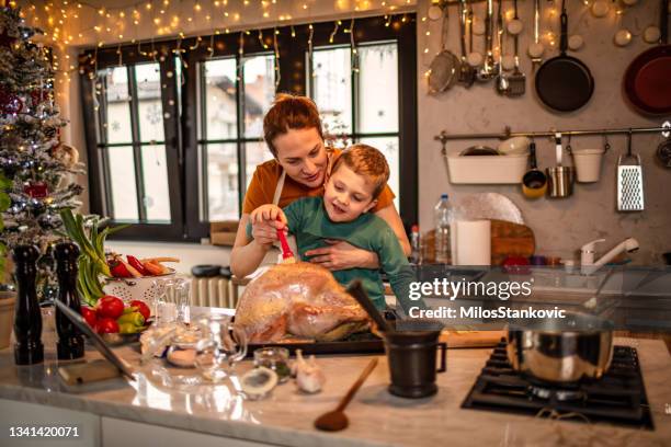 mother and boy preparing a christmas dinner together - raw chicken stock pictures, royalty-free photos & images