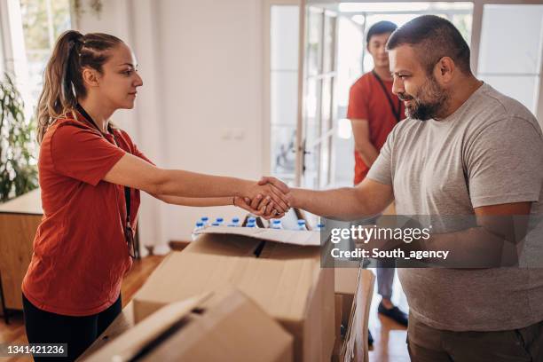 man donating boxes with food and clothes in donation center where volunteers are sorting packages - carer allowance stock pictures, royalty-free photos & images