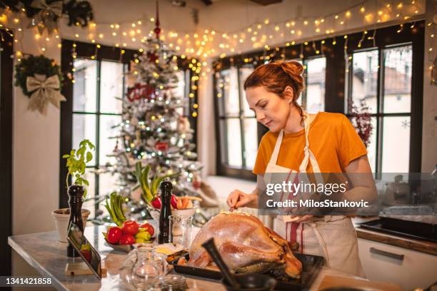 preparing stuffed turkey for holidays - stuffed turkey stock pictures, royalty-free photos & images