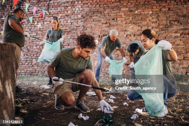 volunteers cleaning garbage after music festival/ concert - nature resources and conservation agency stock pictures, royalty-free photos & images