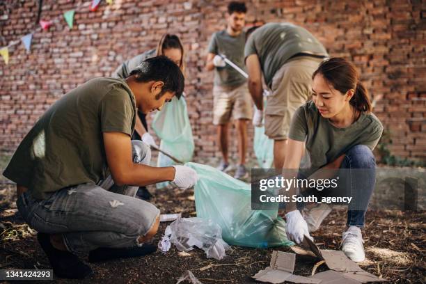 volunteers cleaning garbage after music festival/ concert - concert in aid of peace one day after party stockfoto's en -beelden